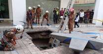 Moment woman is swallowed by 26-foot sinkhole in pavement - and is still missing 6 days laterSinkhole