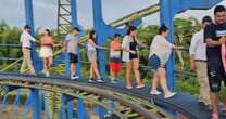 Moment stranded thrill-seekers forced to flee broken rollercoaster on precarious track