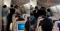 Terrifying moment passenger tries to open emergency door mid-flight before crew grab him