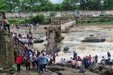 One person dead as major bridge at tourist hotspot collapses and several swept away