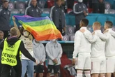 Pitch invader with rainbow flag storms in front of Hungary team during national anthem