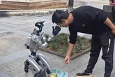 Robot spotted begging for cash on its knees in street after hitting rock bot-tom