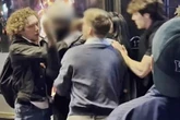 Phone thief has balaclava whipped off face as group screaming 'w***er' surround him