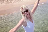 Holly Willoughby beams as she soaks up the sun in plunging white swimsuit