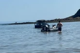 Baffled beachgoers say 'how did it get there' as car is seen submerged in water