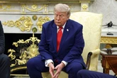Sleepy Donald Trump looks ready for a nap as he sits surrounded by massive golden urns