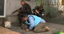 Repórter do SBT se protege atrás de policiais durante tiroteio no Rio
