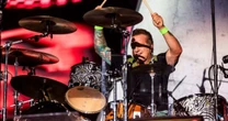 Tré Cool, baterista do Green Day, compra pano de prato das mãos de uma criança em São Paulo; assista