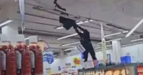 Policial militar sobe em gôndola e tira homem pendurado no teto de supermercado no RJ