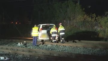 Manhunt for driver after car crashes onto railway tracks