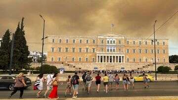 A wildfire near Greece's capital darkens the skies over Athens and advances fast