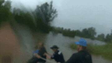 Police wade through deep floodwaters to save woman trapped in car