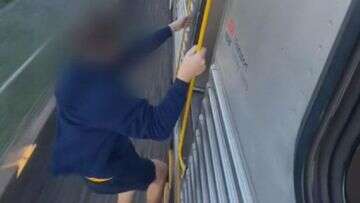 'Sickening' footage shows teenager hanging off the side of train