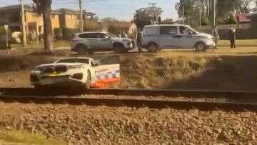 Police narrowly avoid being hit by train chasing motorcyclist in Sydney