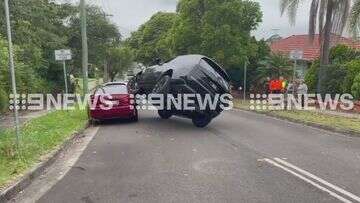 Range Rover stuck mid-air perched on hatchback on Sydney street