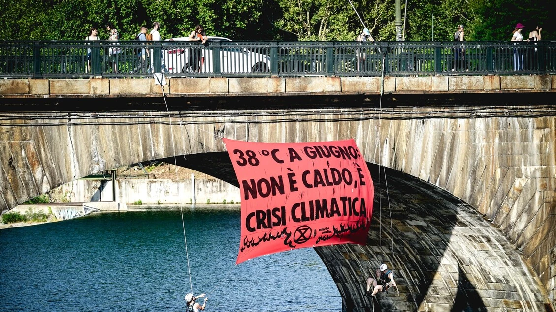 Attivisti ambiente giù da un ponte con striscione a Torino