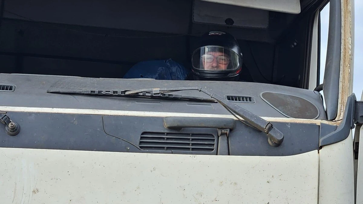 Motorista usa capacete para substituir para-brisa de carreta