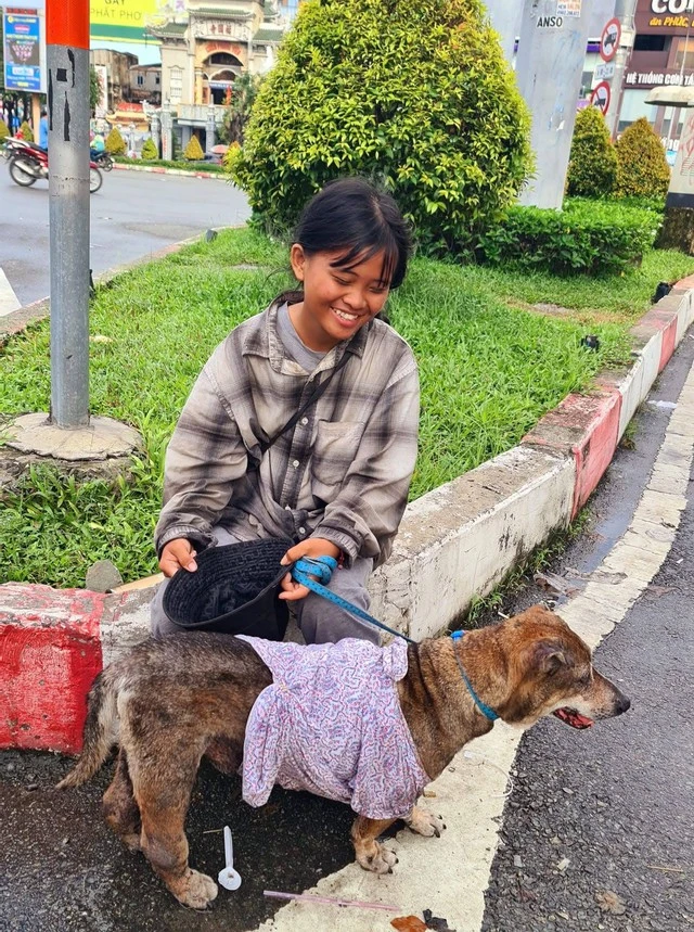 Câu chuyện sau bức ảnh cô bé ăn xin ôm chú chó già ở ngã tư Hàng Xanh