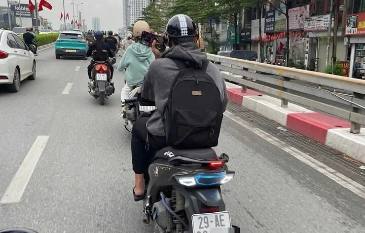 Thanh niên vừa lái xe vừa lướt điện thoại bị xử phạt 900.000 đồng