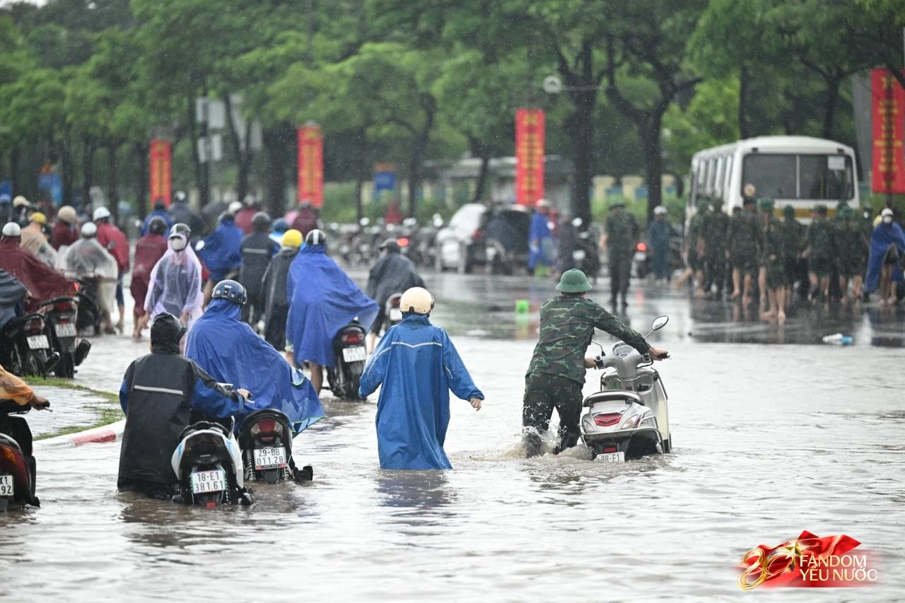 Ảnh đẹp sáng nay: Các chiến sĩ làm nhiệm vụ A80 lội nước đẩy xe, dìu dân qua đoạn ngập sâu ở Hà Nội
