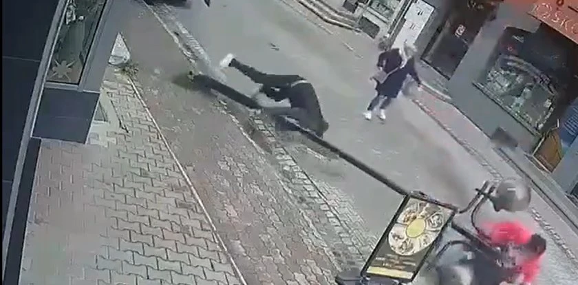Niefortunny wypadek. Lampa uliczna runęła na przechodnia. Wszystko uchwyciły kamery