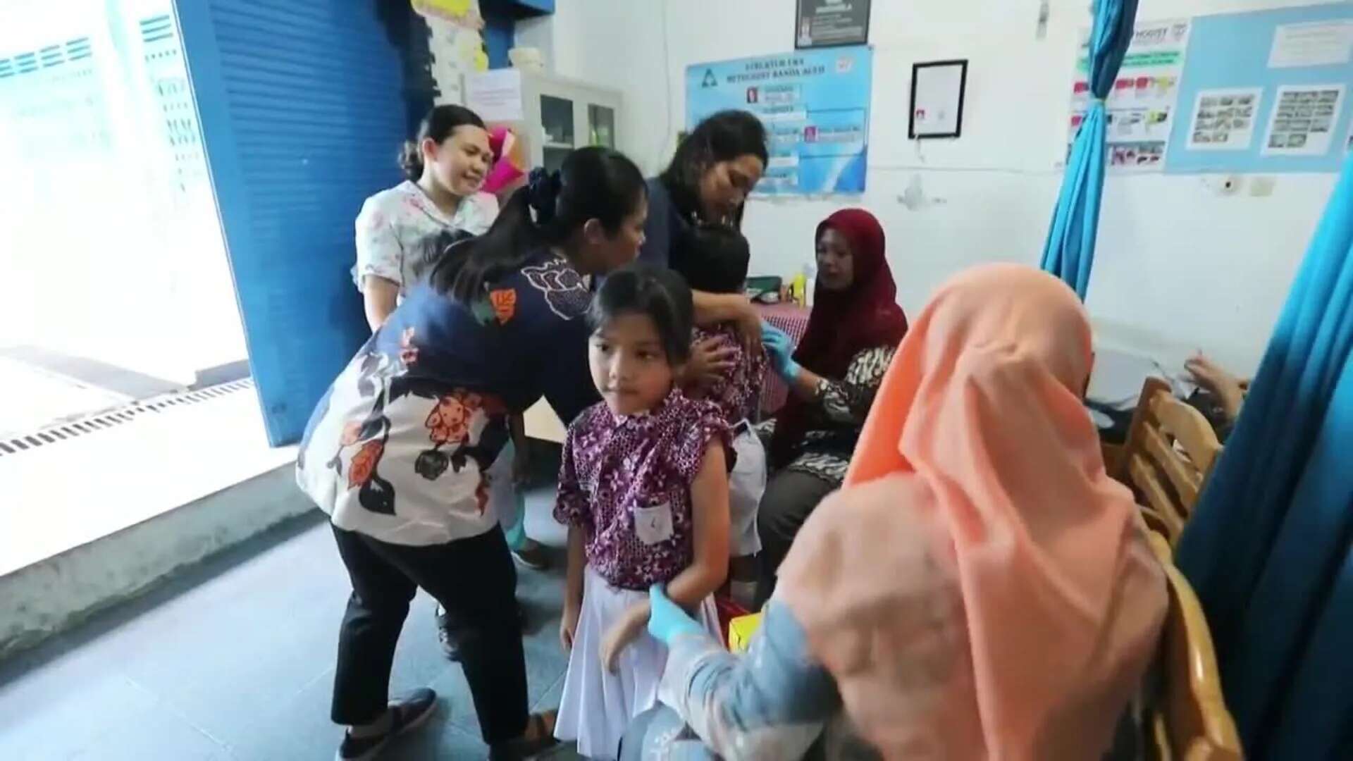 Trabajadores indonesios administran dosis de vacuna contra la difteria dentro de un programa educativo