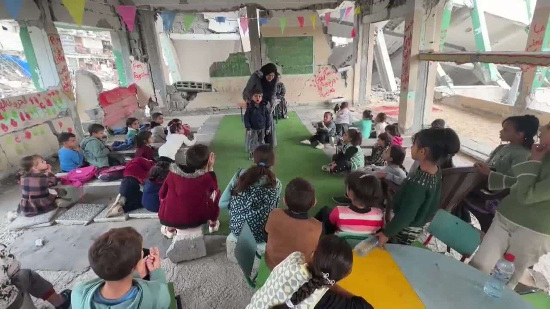 Niños palestinos imparten clases en un aula sobre escombros