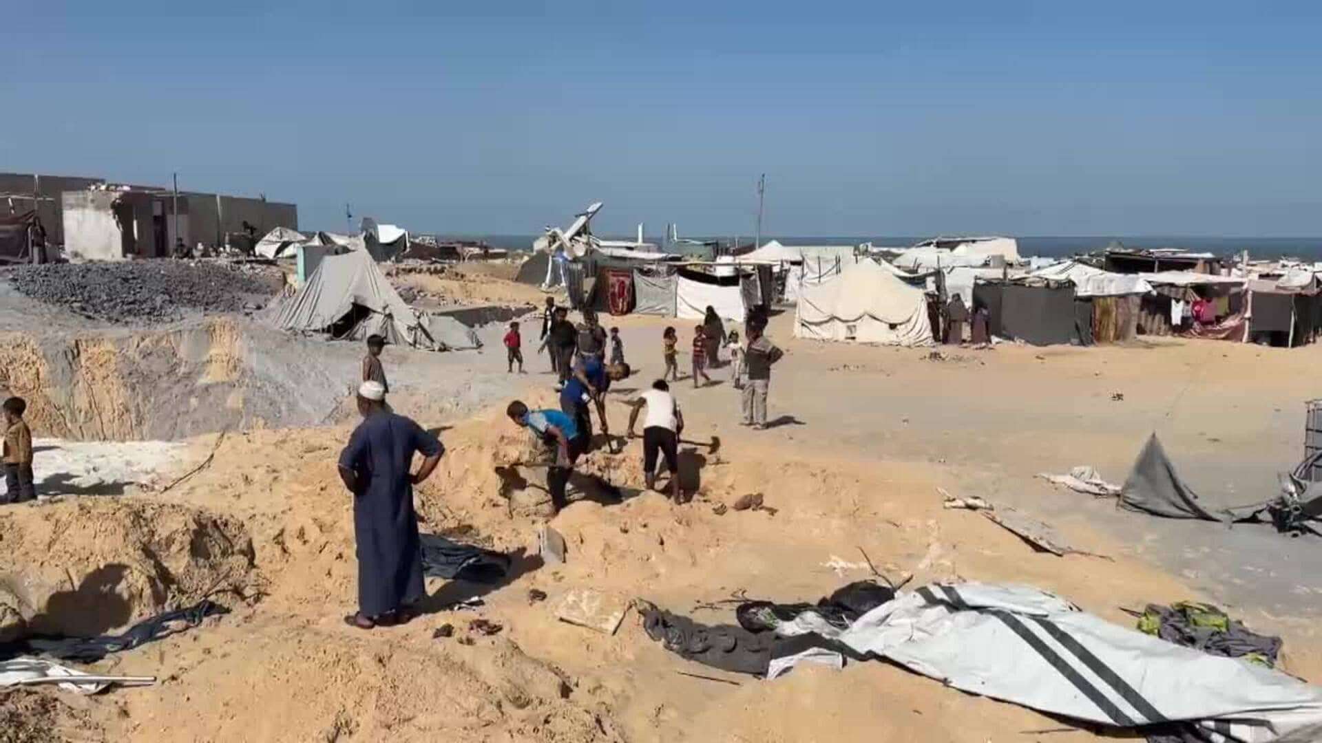 Palestinos inspeccionan sus tiendas en la zona de Al-Mawasi, después de que el ejército israelí atacara el refugio