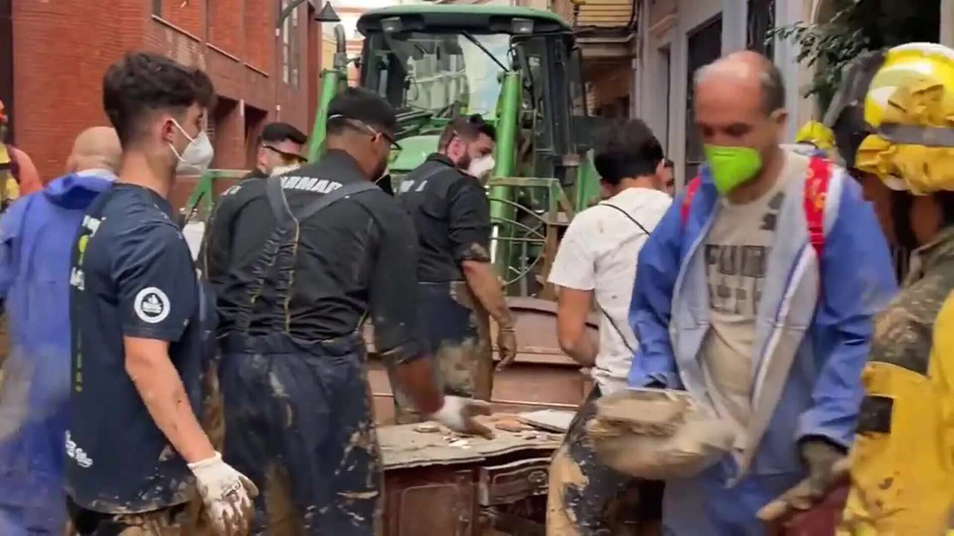 Efectivos del contingente aragonés junto a voluntarios limpian este sábado una calle de Catarroja