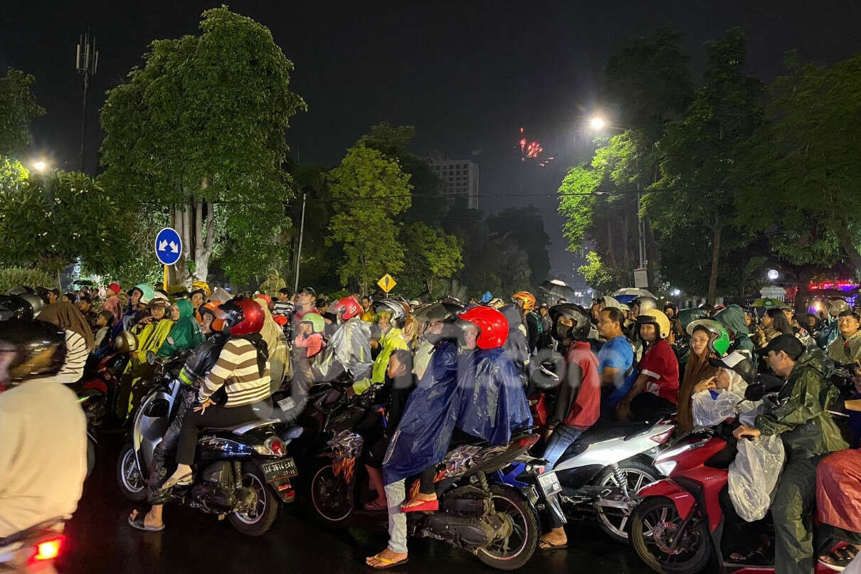 Diguyur Hujan, Warga Tetap Antusias Memeriahkan Pergantian Tahun di Surabaya