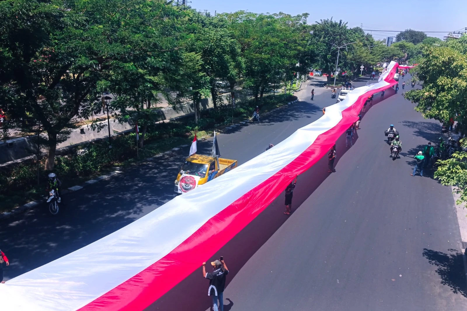 Demo Sopir Truk Bentangkan Bendera Merah Putih 1.000 M Diarak ke Kantor Gubernur Jatim