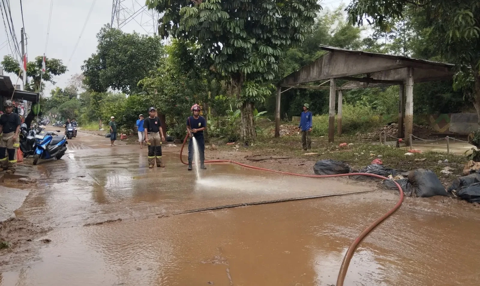 Damkar Bantu Bersihkan Lumpur Pascabanjir di Villa Pamulang Depok