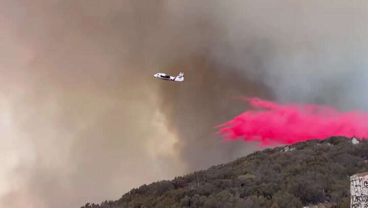 Firefighters tackle San Diego wildfire blaze from air with pink powder