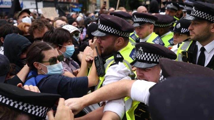 Police scuffle with protesters outside hotel housing immigrants