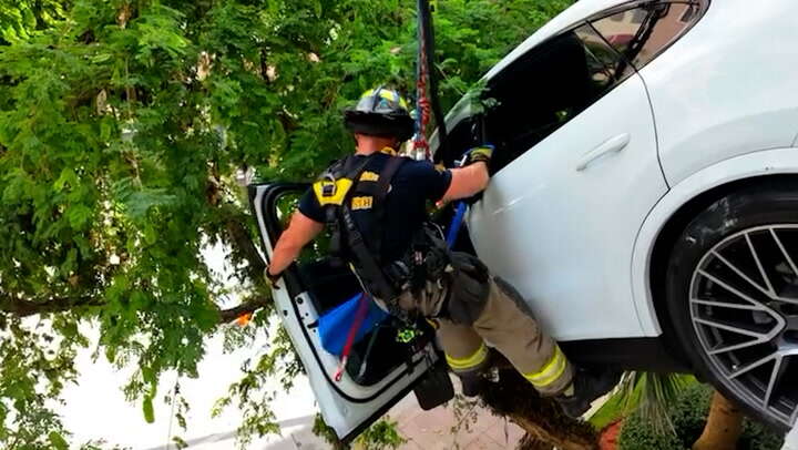 Woman rescued after crash leaves Porsche dangling from Florida garage