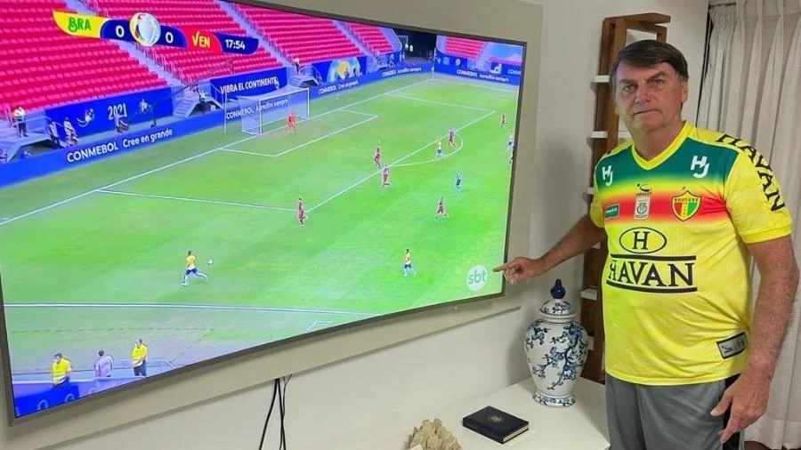 Bolsonaro vê Brasil na Copa América e tira foto apontando para logo do SBT