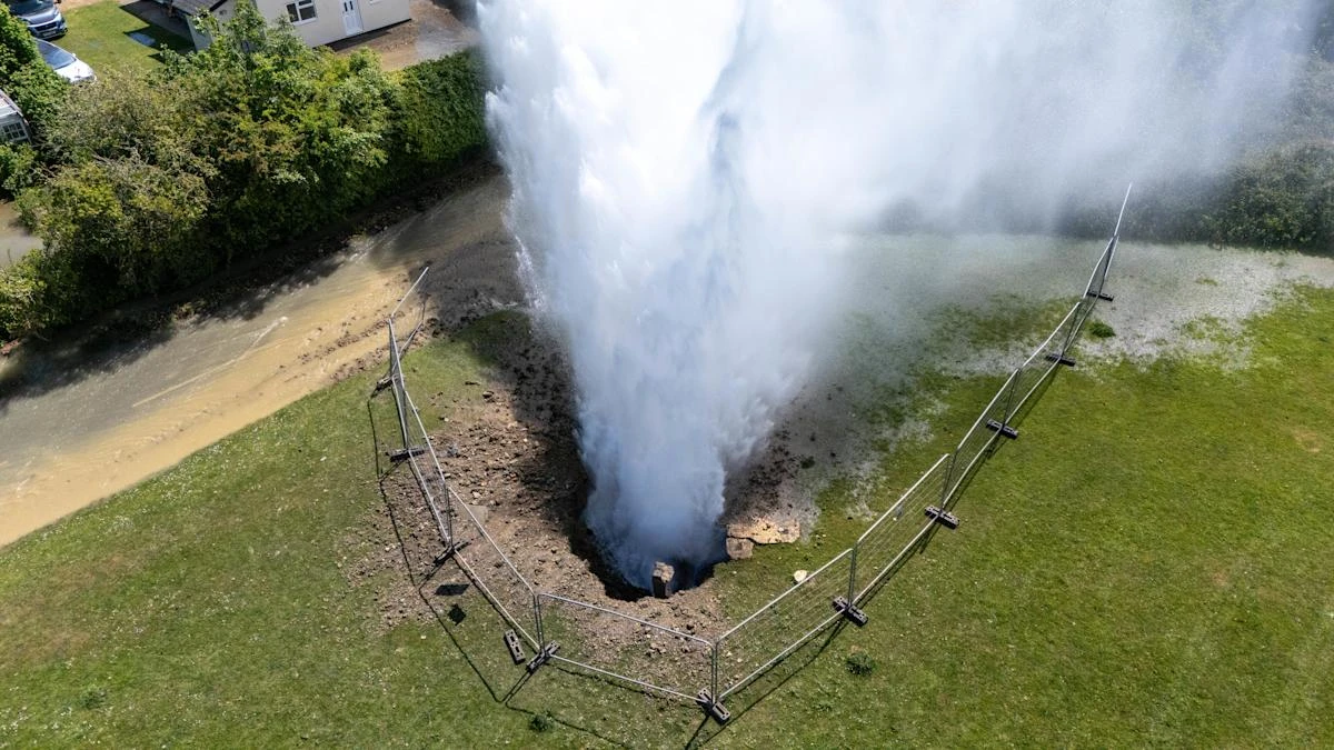 Residential street flooded as burst main shoots 100ft jet of water into the air