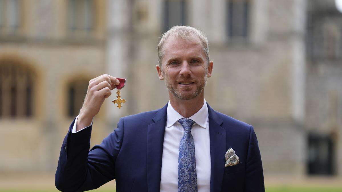 Former rugby referee Wayne Barnes jokes with William as he is made an OBE