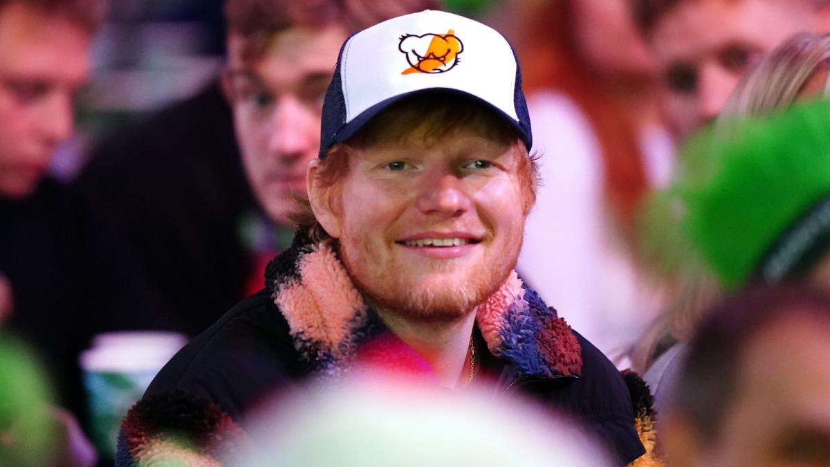 Ed Sheeran watches darts championship wearing cap with hot sauce logo