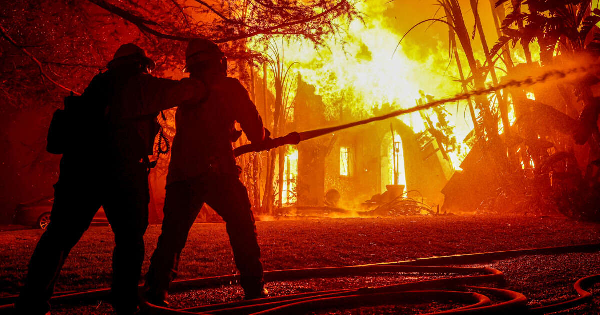 At least two dead as uncontrolled fires rage around L.A.