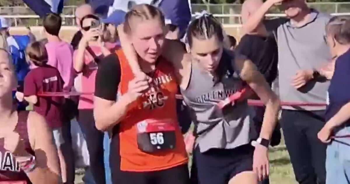 Arkansas runner helps competitor cross finish line