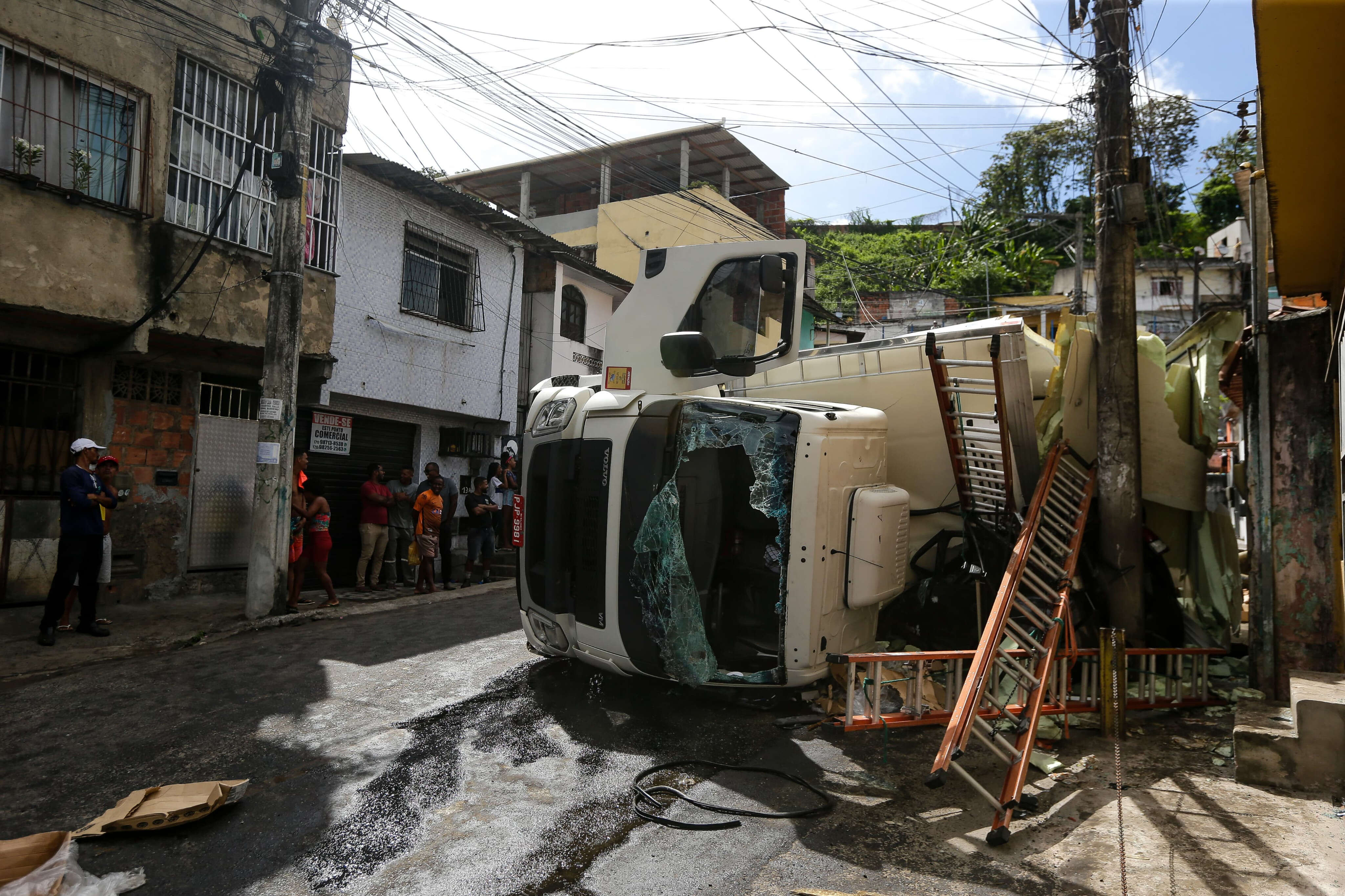 Caminhão tomba na estrada do Lobato, destrói veículo estacionado e é saqueado por moradores