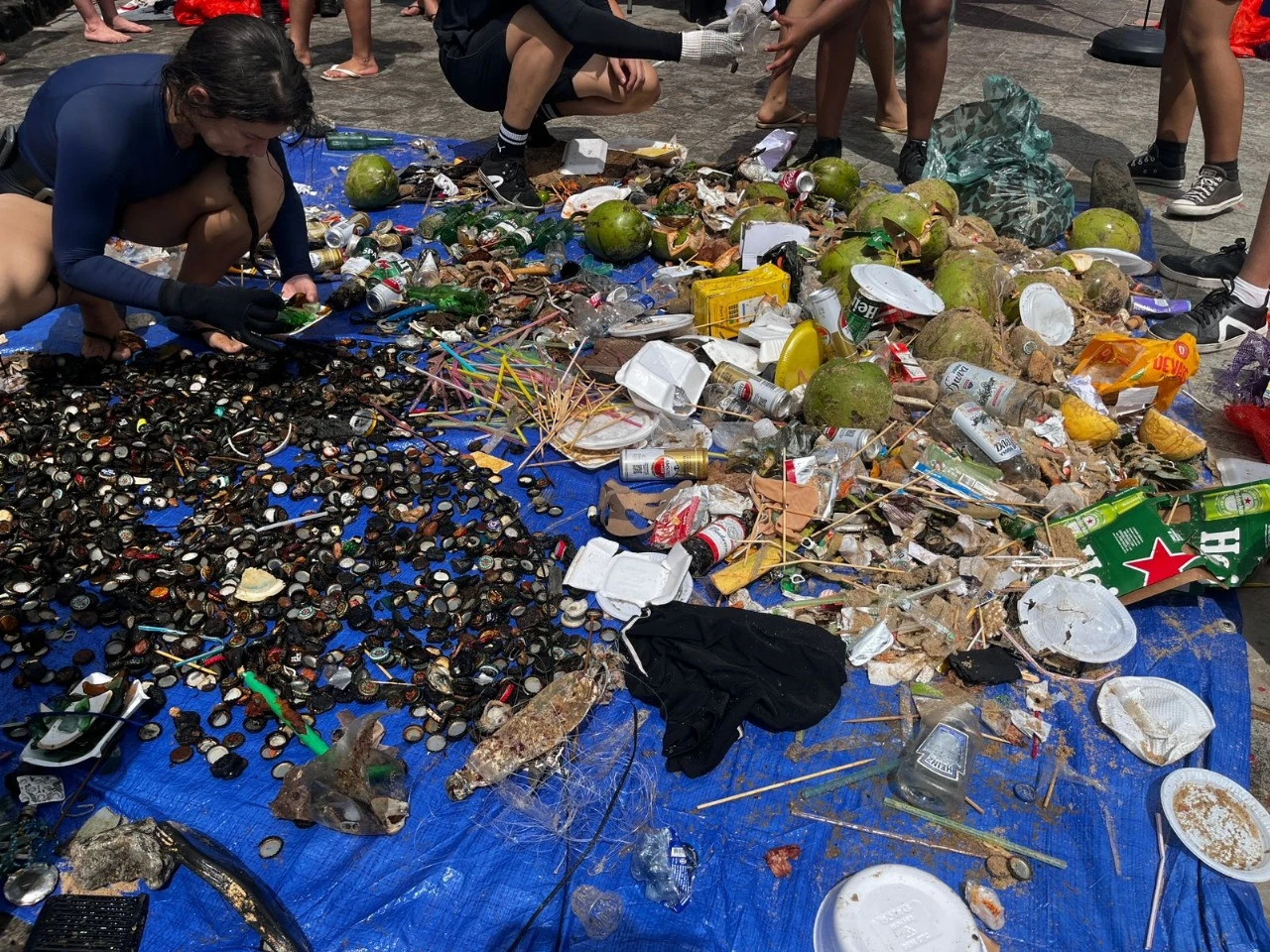Vidro, isqueiros e até roupa: cerca de 180 kg de lixo são retirados do mar no Porto da Barra