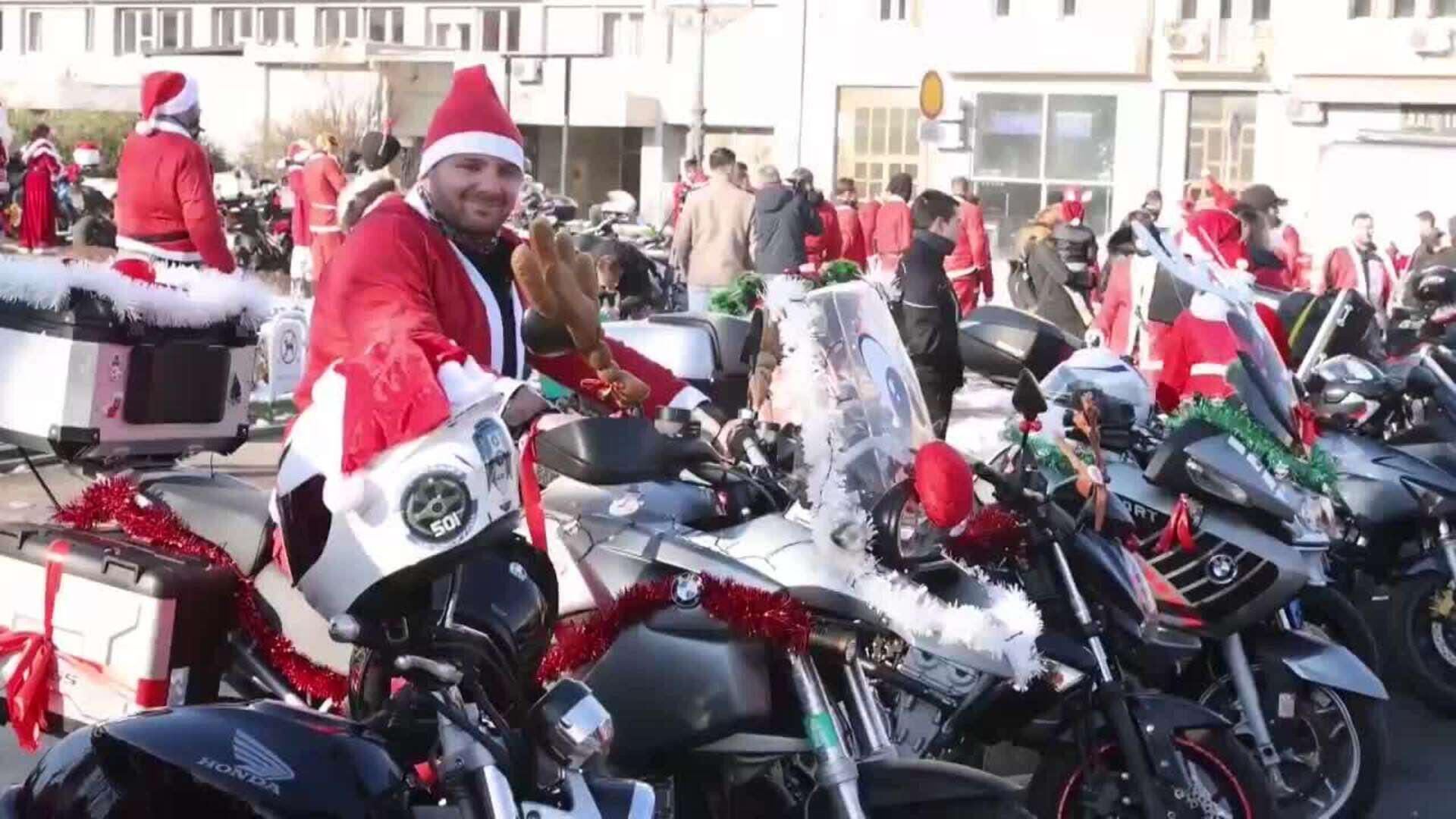 Motociclistas disfrazados de Papá Noel entregan regalos a niños en Belgrado