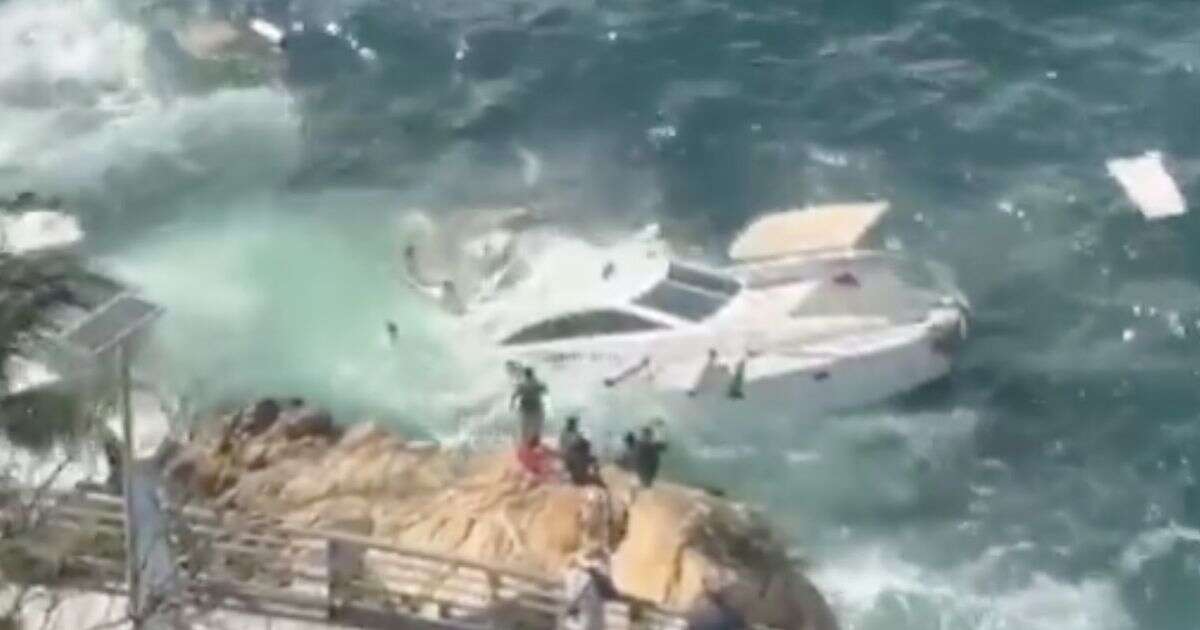 Terrifying moment yacht full of tourists smashes into rocks and sinks on New Year's Day