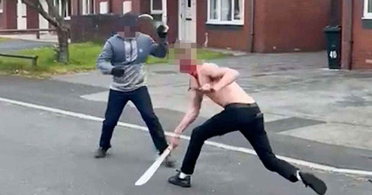 Bloodied men slash each other with machetes in street as woman begs them to stop