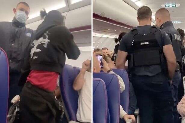 Moment drunk woman hauled off flight by cops as passengers rage over 'bedlam'