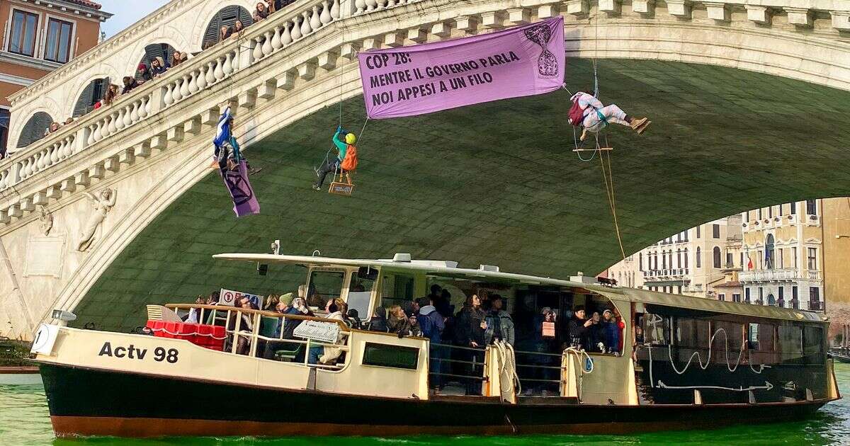 Venice’s famous Grand Canal dyed fluorescent green by activists hanging from bridge