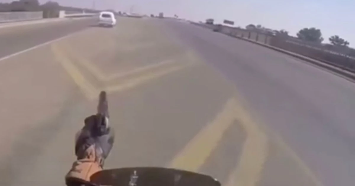 Incredible moment police motorcyclist shoots stolen car's tyres out in wild chase