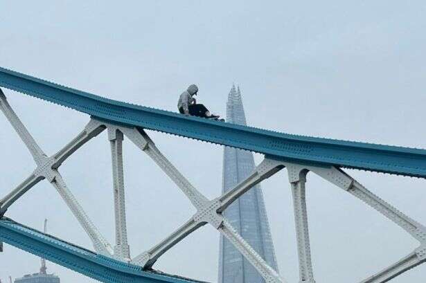 Man climbing Tower Bridge with hood up brings London traffic to standstill